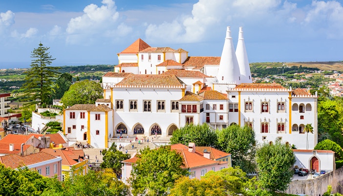 Sintra National Palace with iconic chimneys and surrounding landscape in Portugal.