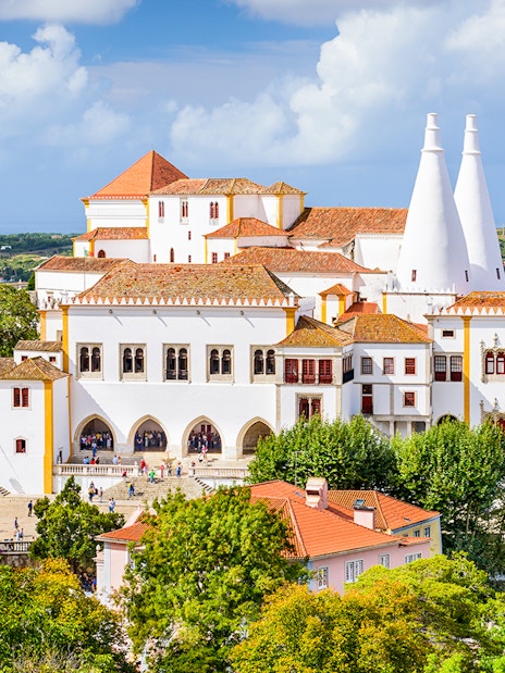 Sintra National Palace with iconic chimneys and surrounding landscape in Portugal.