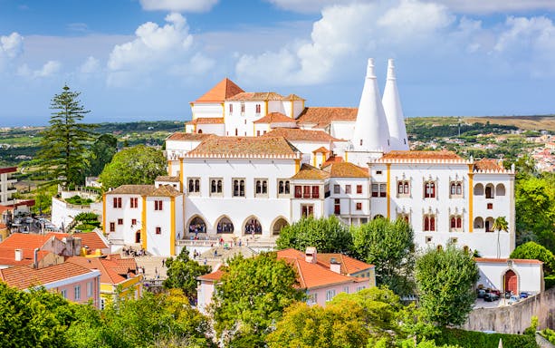 Sintra National Palace with iconic chimneys and surrounding landscape in Portugal.