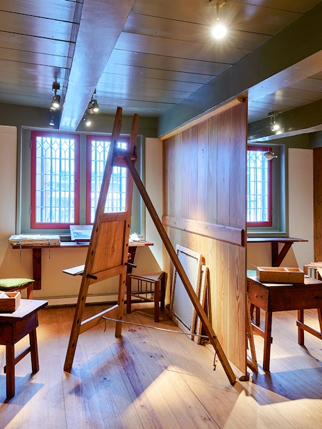 Rembrandt House Museum interior with easels and wooden furniture.