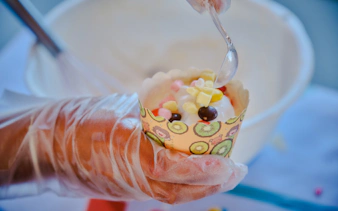 Decorating a cupcake with colorful toppings at a birthday party in Phuket.