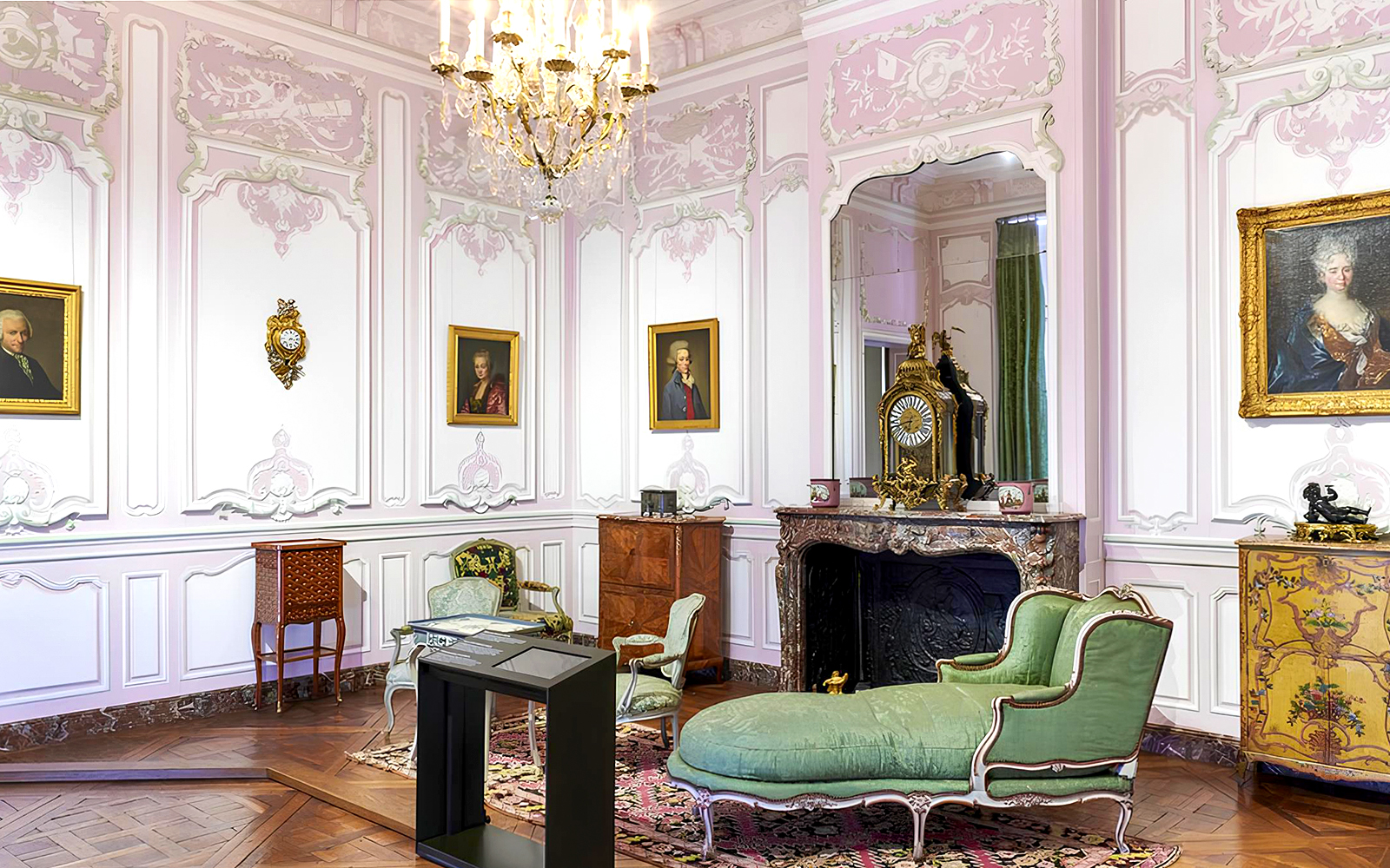 Elegant room in Carnavalet Museum with ornate furniture and historical portraits.