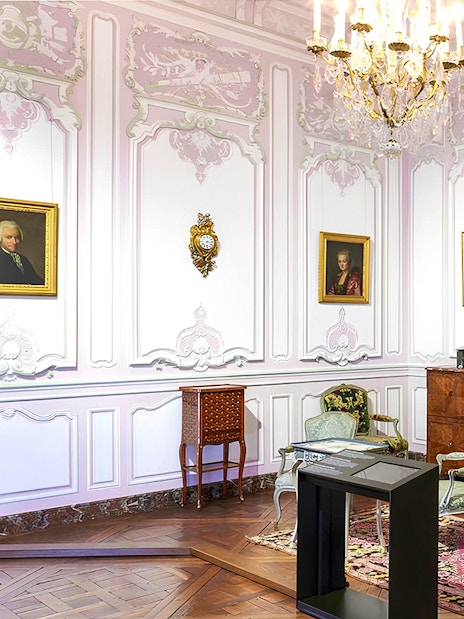 Elegant room in Carnavalet Museum with ornate furniture and historical portraits.