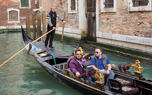 Gondola ride through Venice canal during full-day tour from Lake Garda.