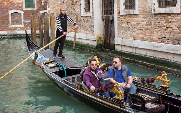 Gondola ride through Venice canal during full-day tour from Lake Garda.