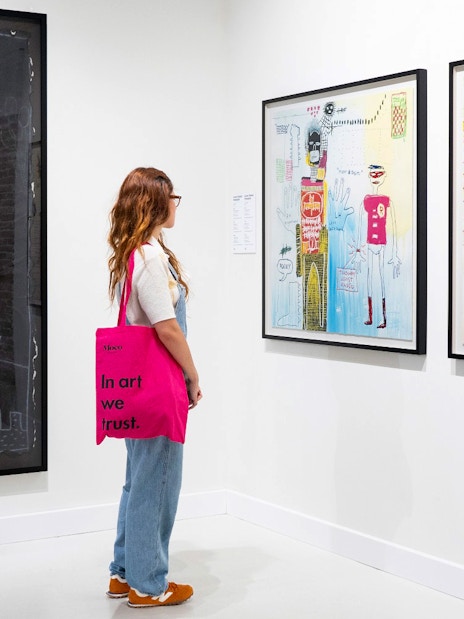 Woman viewing modern art at Moco Museum exhibition.