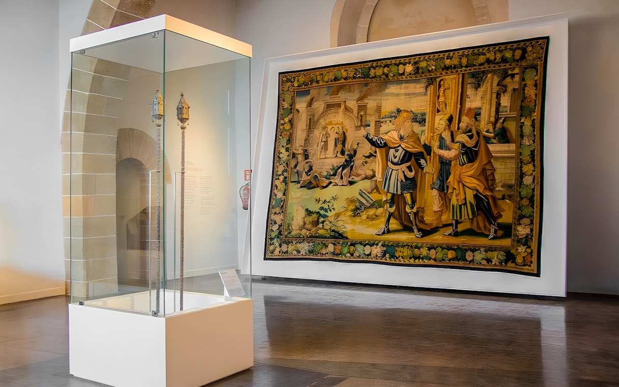 Mallorca Cathedral interior with historical tapestry and artifact display.