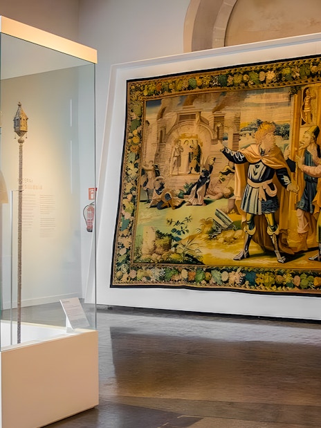 Mallorca Cathedral interior with historical tapestry and artifact display.