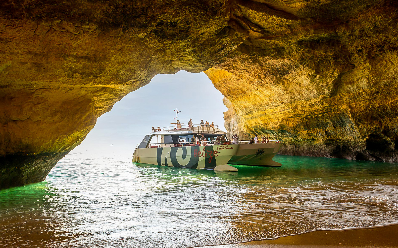 Catamaran entering Benagil Cave on Algarve sightseeing cruise from Albufeira.