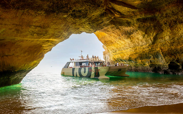 Catamaran entering Benagil Cave on Algarve sightseeing cruise from Albufeira.