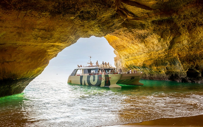 Catamaran entering Benagil Cave on Algarve sightseeing cruise from Albufeira.