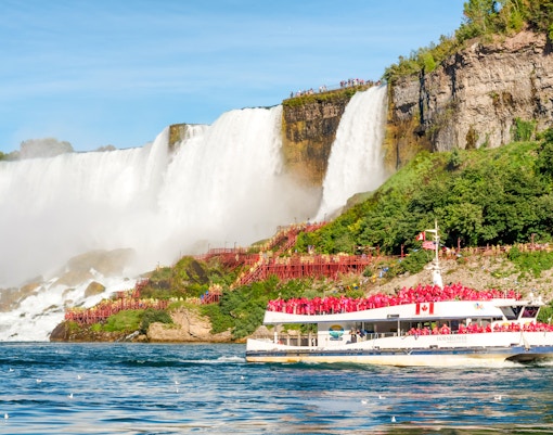 Tourists on Hornblower boat at base of Horseshoe Falls, Niagara, experiencing waterfall mist.