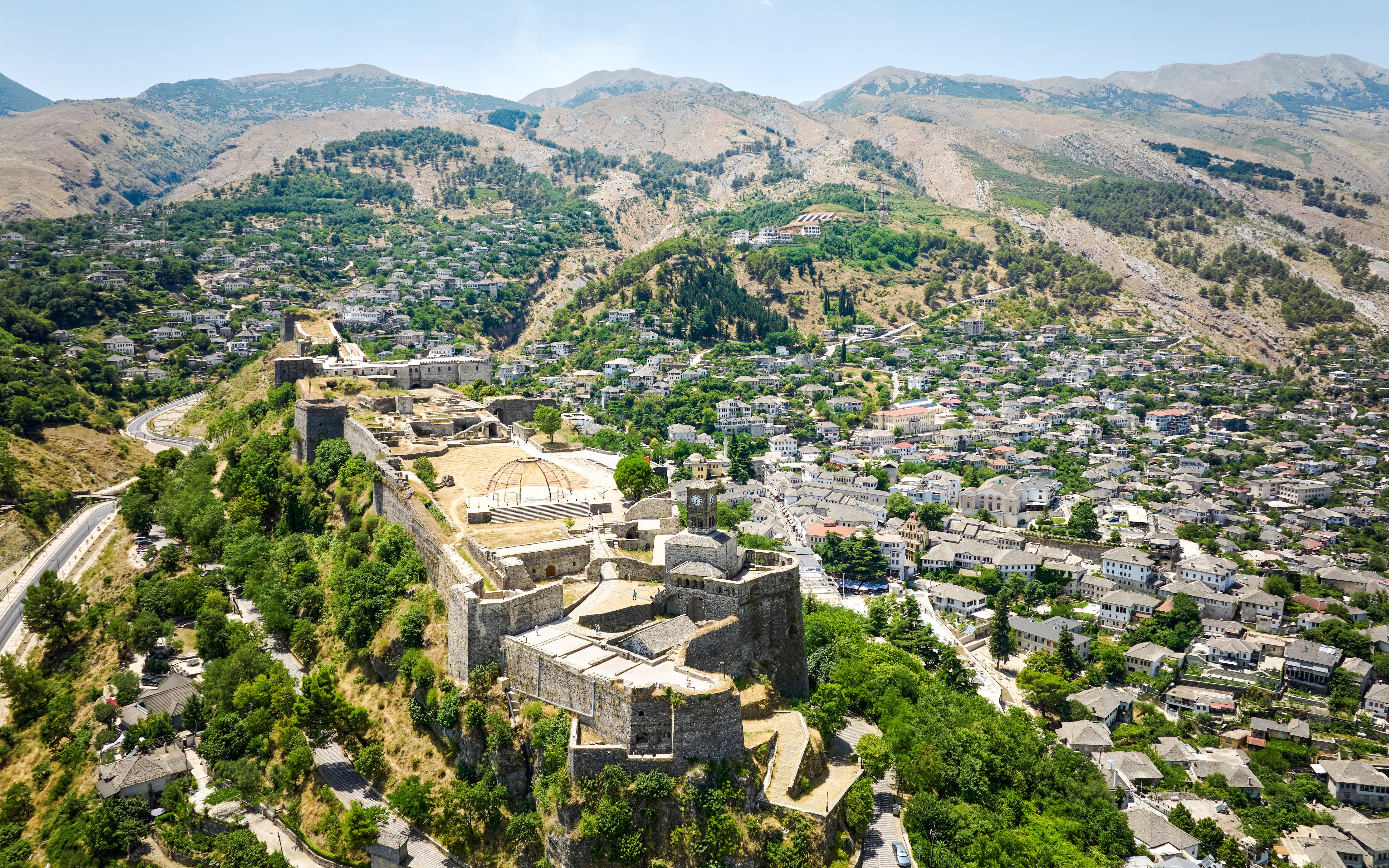 Aerial view of Gjirokastra Castle in Albania with surrounding landscape and town.