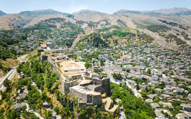 Aerial view of Gjirokastra Castle in Albania with surrounding landscape and town.
