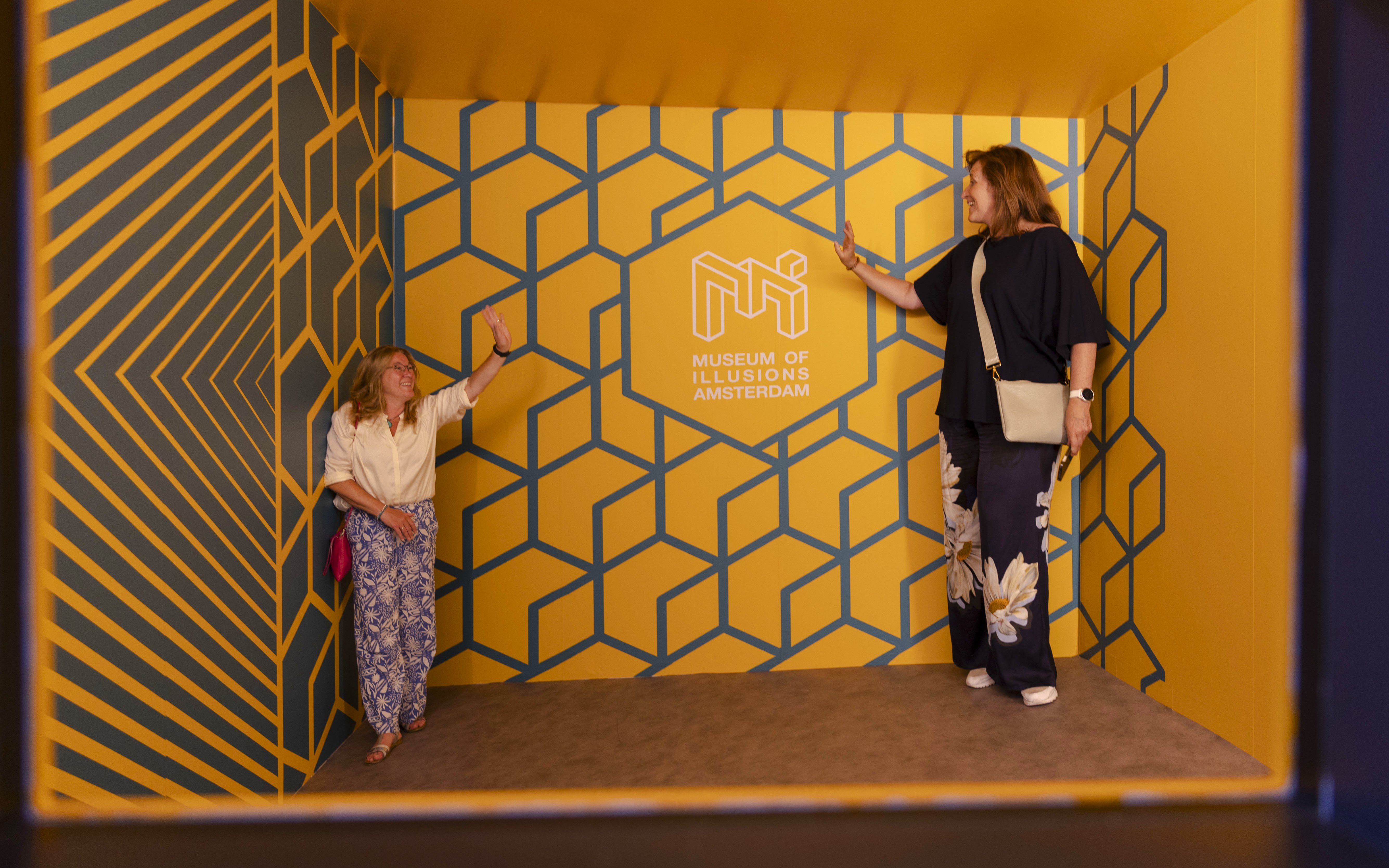 Guests interacting in an optical illusion room at the Museum of Illusions Amsterdam.