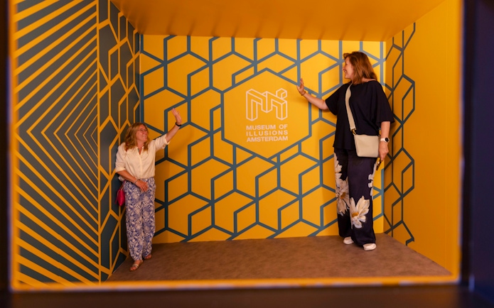 Guests interacting in an optical illusion room at the Museum of Illusions Amsterdam.