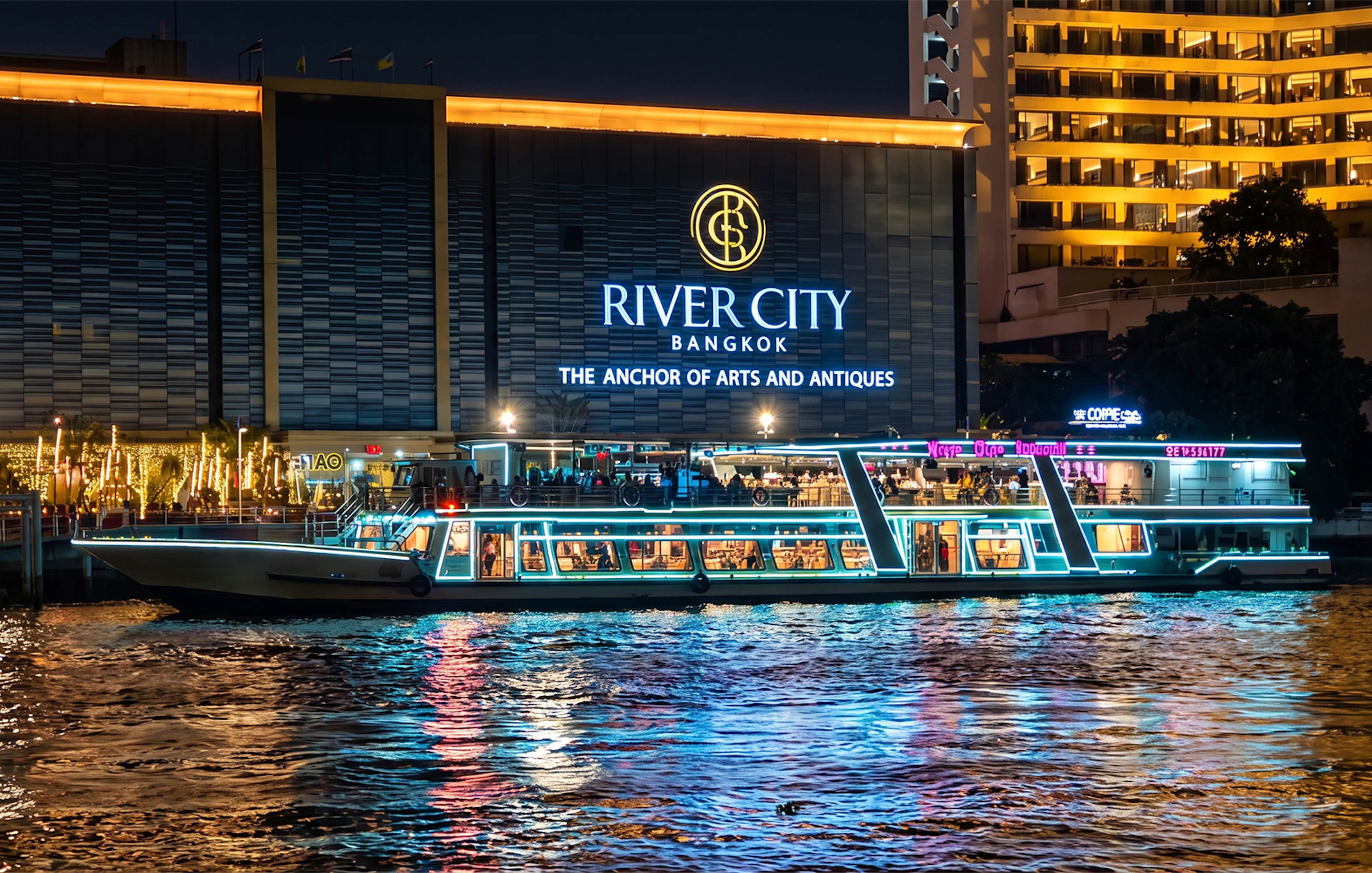 River Star Princess cruise on Chao Phraya River at night, passing River City Bangkok.