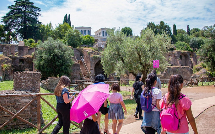 Families exploring ancient ruins near the Colosseum in Rome.