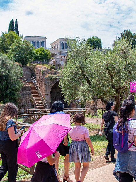 Families exploring ancient ruins near the Colosseum in Rome.