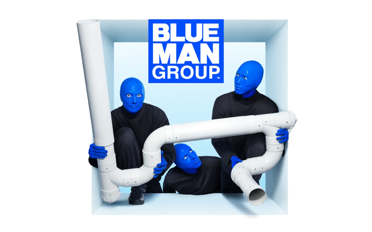 Blue Man Group performers with PVC pipes in a creative pose.
