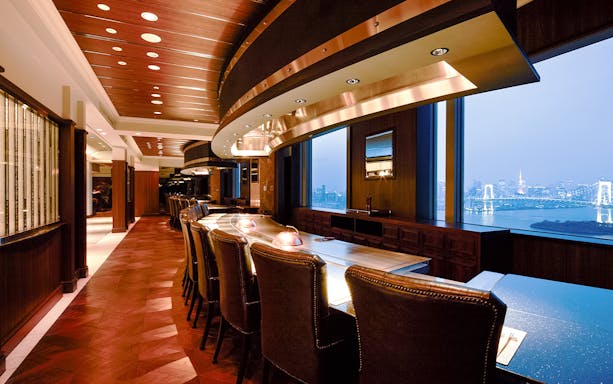 Teppanyaki Ichou dining area with city skyline view, featuring Kuroge Wagyu beef course.