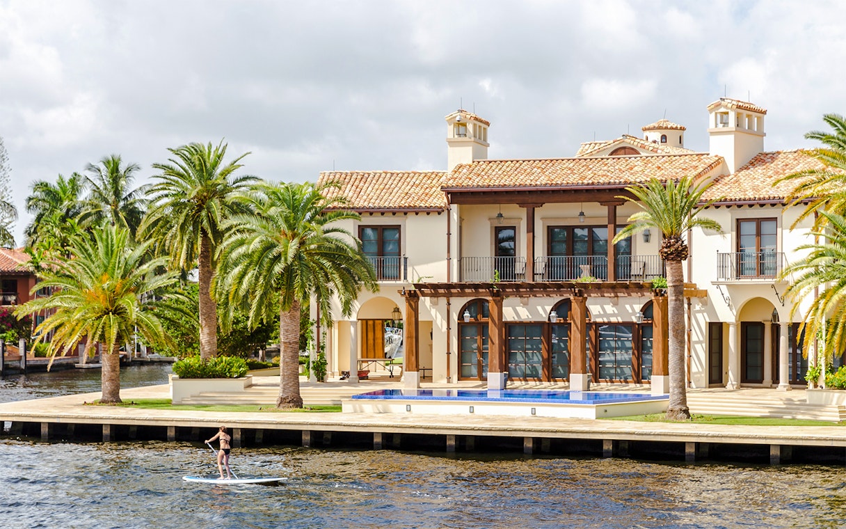 Luxury mansion with palm trees by the water in Fort Lauderdale, Florida.