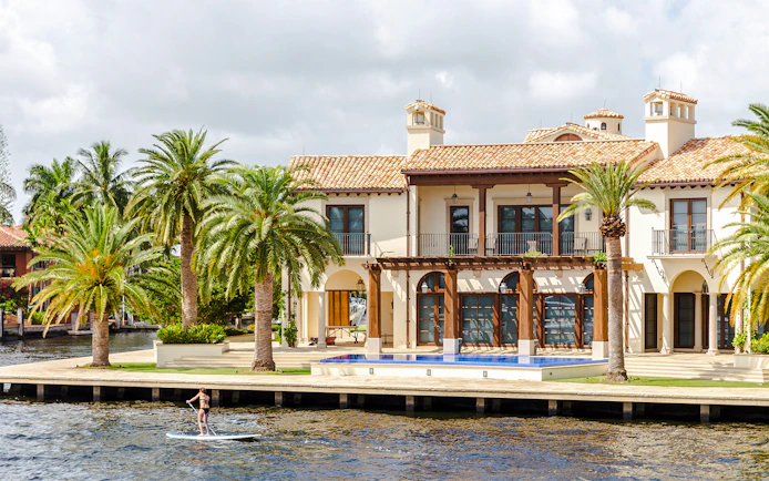 Luxury mansion with palm trees by the water in Fort Lauderdale, Florida.