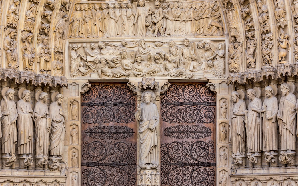 Notre Dame Cathedral facade with detailed sculptures, Paris.