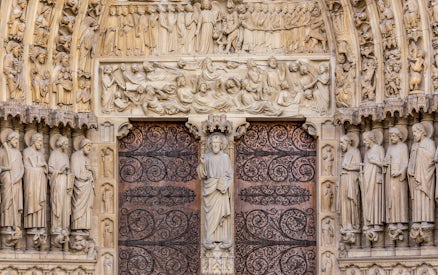 Notre Dame Cathedral facade with detailed sculptures, Paris.