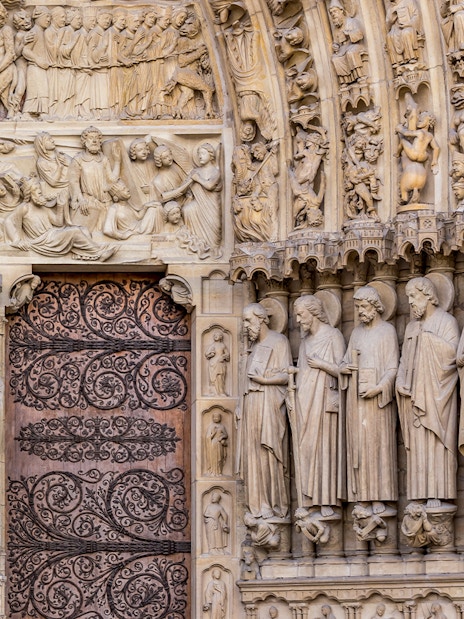 Notre Dame Cathedral facade with detailed sculptures, Paris.