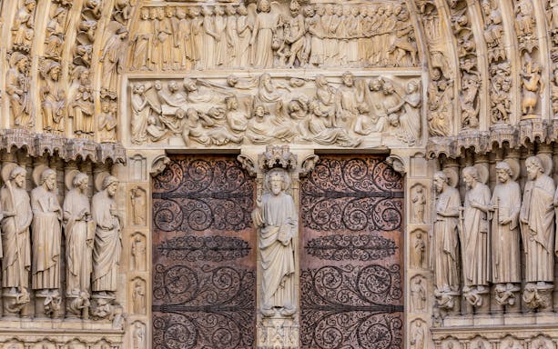 Notre Dame Cathedral facade with detailed sculptures, Paris.