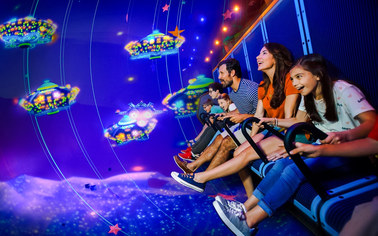 Family enjoying a ride at LEGOLAND® California with colorful virtual spaceships.