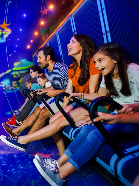 Family enjoying a ride at LEGOLAND® California with colorful virtual spaceships.
