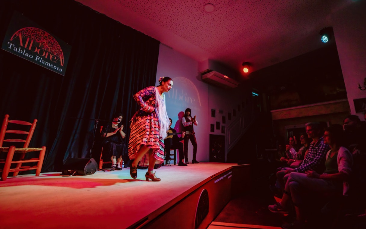 Flamenco dancer performing at La Alboreá in Granada with audience watching.