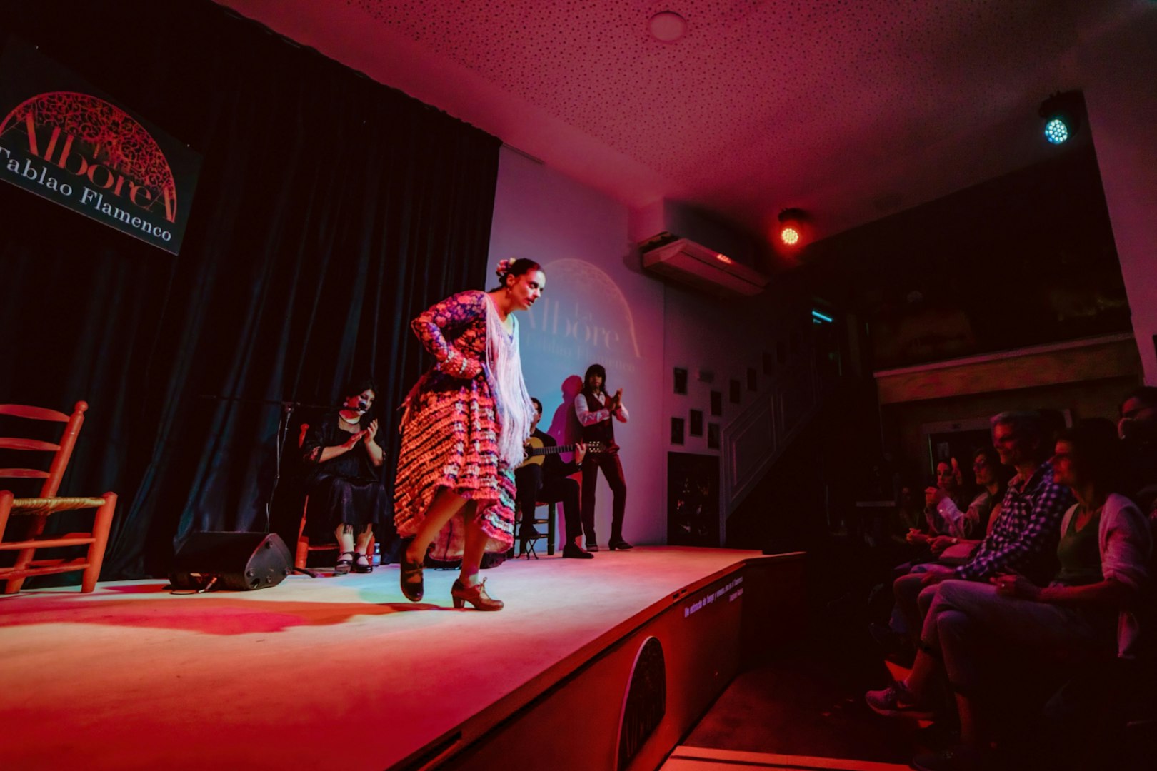 Flamenco dancer performing at La Alboreá in Granada with audience watching.