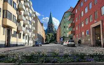 Street view in Södermalm, Stockholm with church spire in the background.