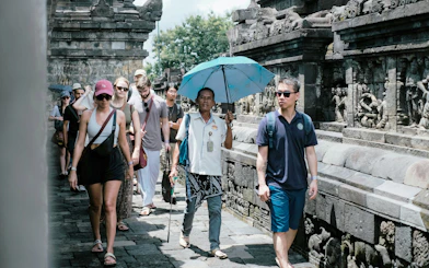 Tourists walking along the stone carvings of Borobudur Temple, Indonesia.
