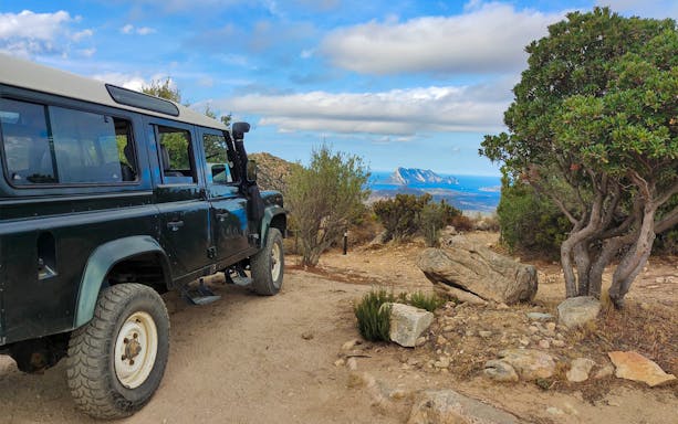 Jeep on a dirt path with a view of Rio Pitrisconi landscape in San Teodoro.