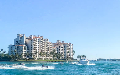Luxury yacht cruising past waterfront homes in Miami.