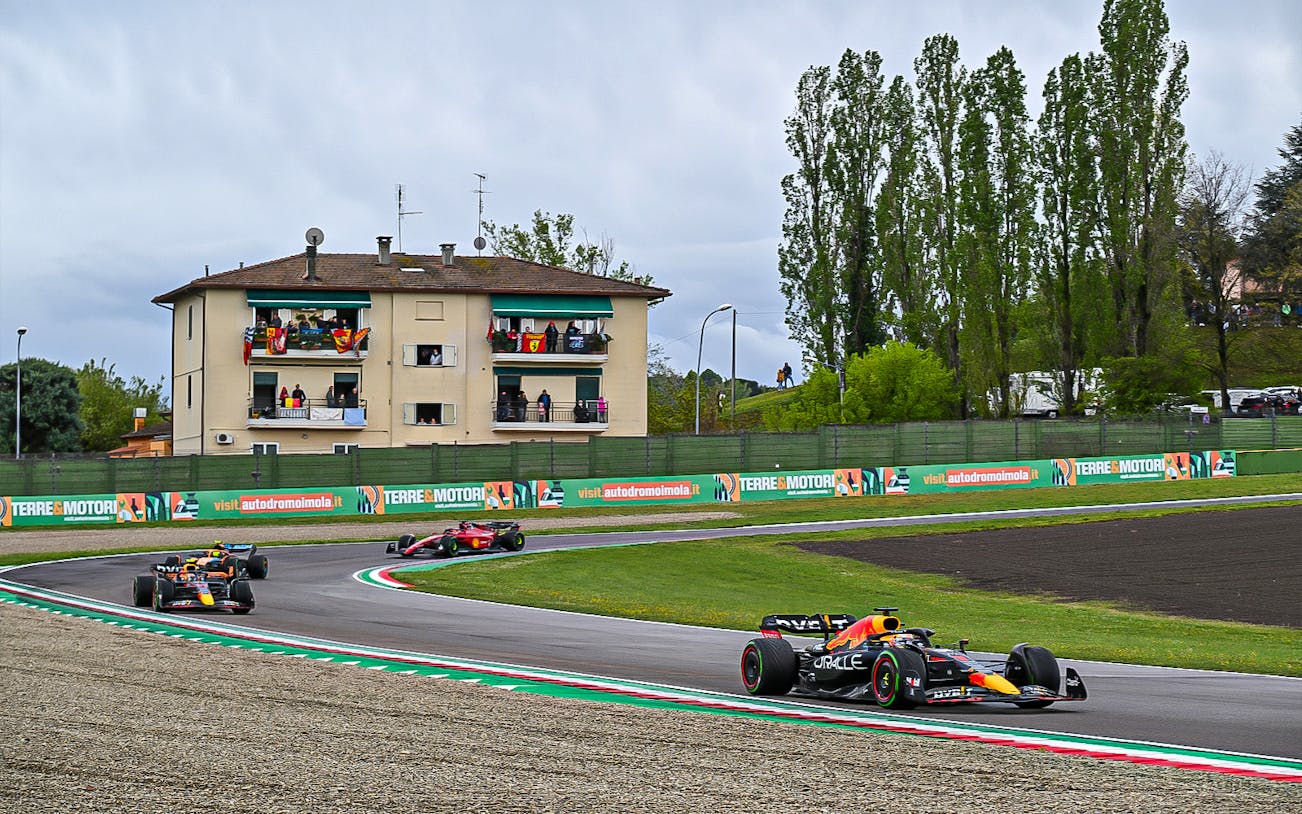 Formula 1 cars racing at Imola circuit during the Emilia-Romagna Grand Prix.