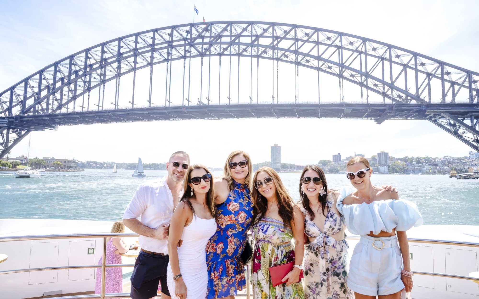 Group enjoying Chandon Harbour Long Lunch on The Jackson with Sydney Harbour Bridge in background.