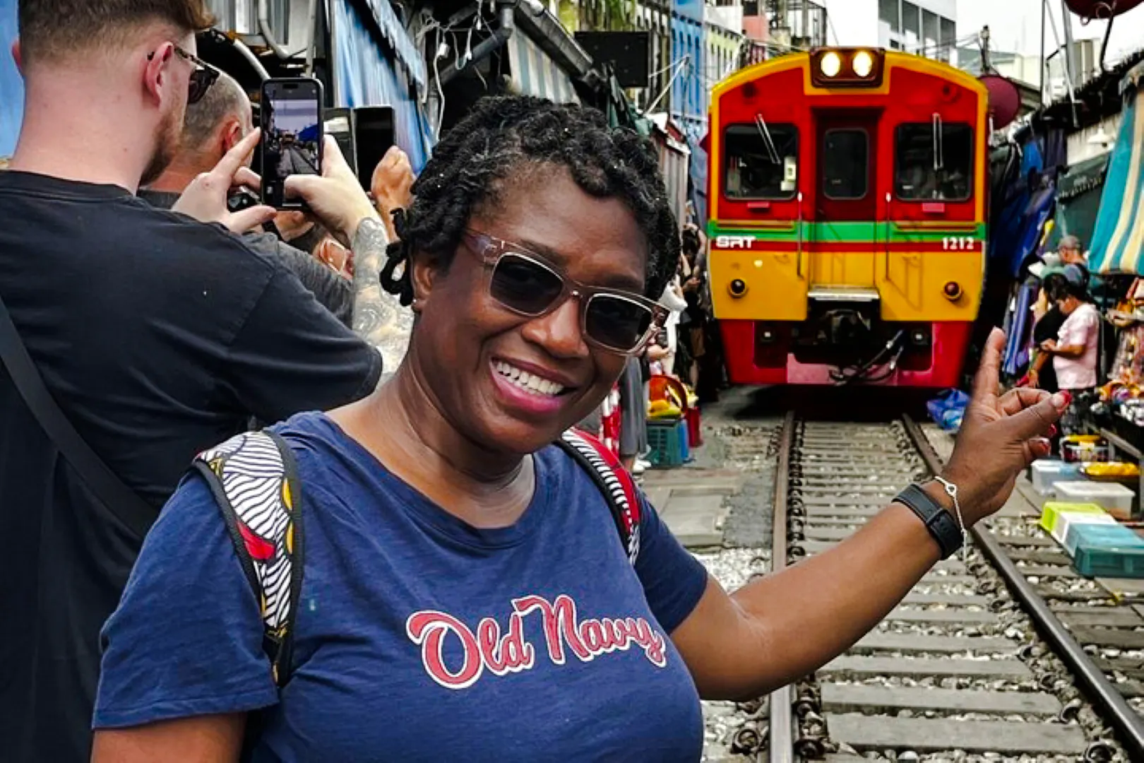 Tourist at Maeklong Railway Market with train approaching, part of Floating Market & Railway Market tour from Laem Chabang, Pattaya.