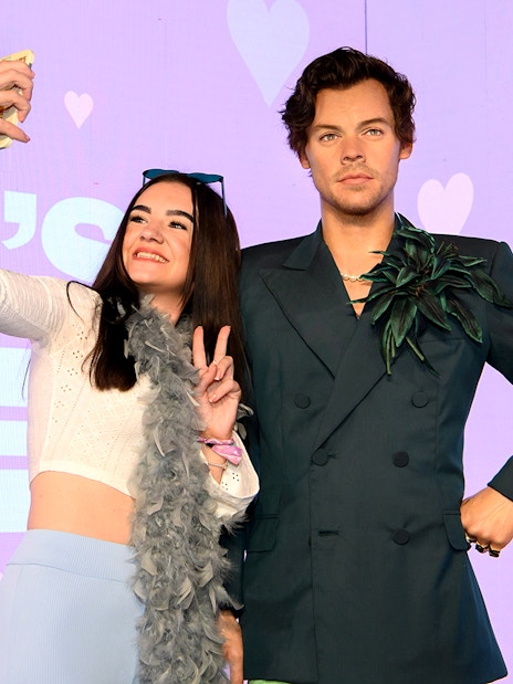 Visitors taking a selfie with Harry Styles wax figure at Madame Tussauds.