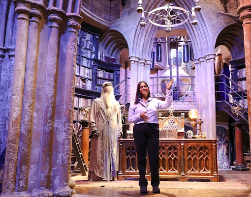 Guide presenting Dumbledore's office at Harry Potter Warner Bros Studio Tour.