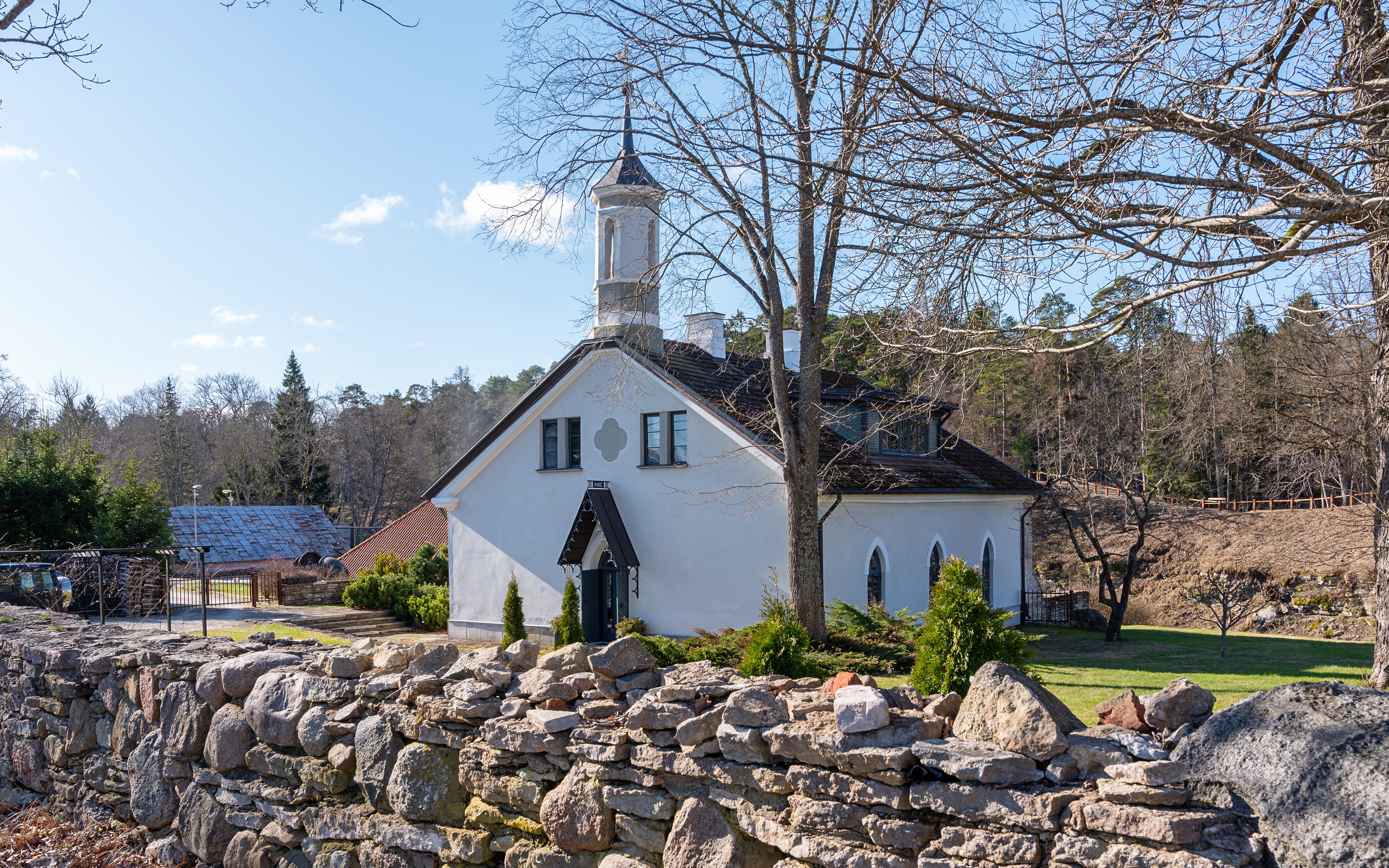 Kelia Joa church in Estonia with stone wall and trees in the background.