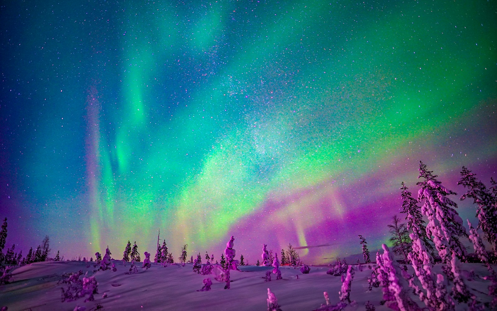 Snowmobiles under Northern Lights in Rovaniemi, Finland.