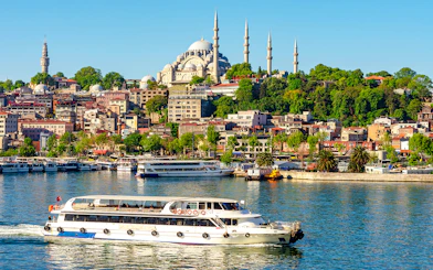 Suleymaniye Mosque overlooking Golden Horn bay with a boat in Istanbul, Turkey.