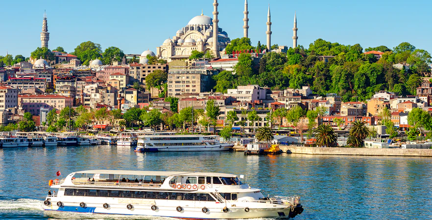 Suleymaniye Mosque overlooking Golden Horn bay with a boat in Istanbul, Turkey.