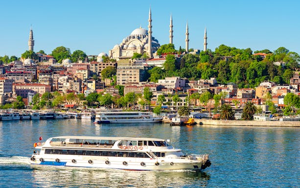Suleymaniye Mosque overlooking Golden Horn bay with a boat in Istanbul, Turkey.
