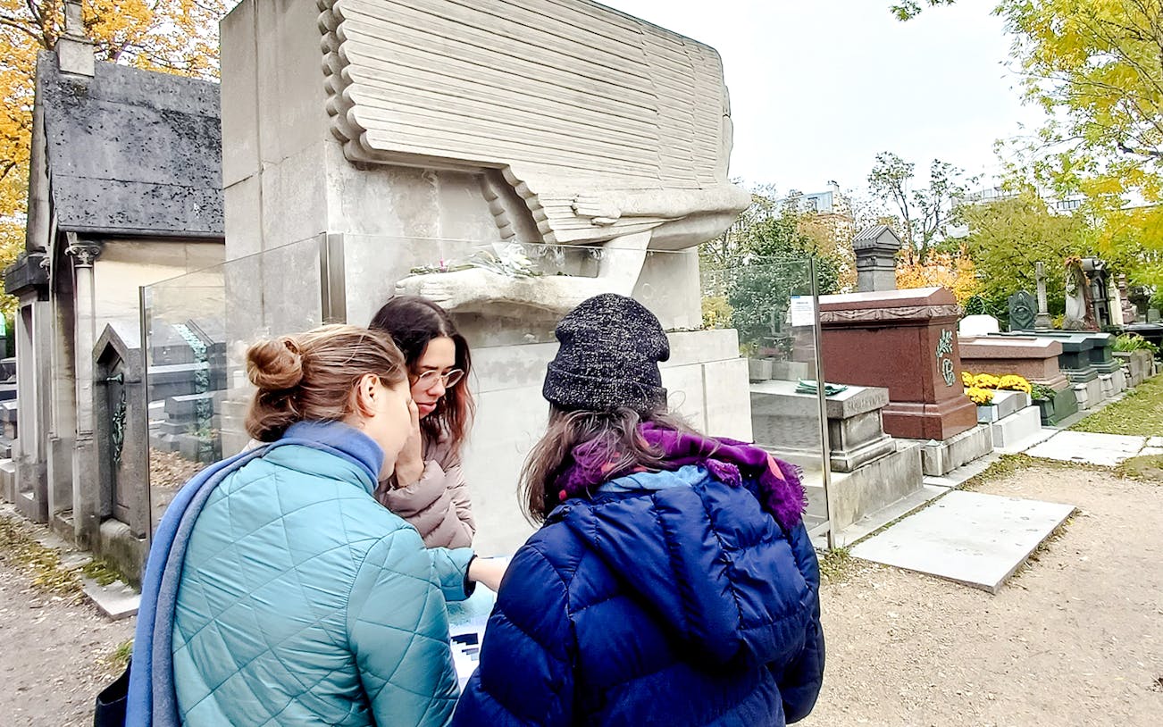 Visitors exploring Père Lachaise Cemetery pathways in Paris, France.